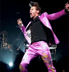 Animated gif of Harry Styles dancing in a shiny purple suit. 