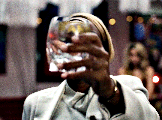 Animated gif from Glass Onion of Janelle Monae as Helen, dropping a glass on the floor