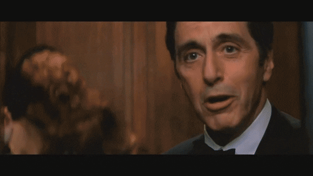 Animated gif from The Devil's Advocate. Keanu Reeves nods and smiles at Al Pacino. Shot cuts back to Al Pacino with two women making out in the background. He suggestively smiles as the elevator door closes.