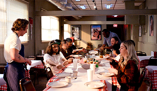 Animated gif of the ensemble cast of The Bear sitting down at a long table for a meal