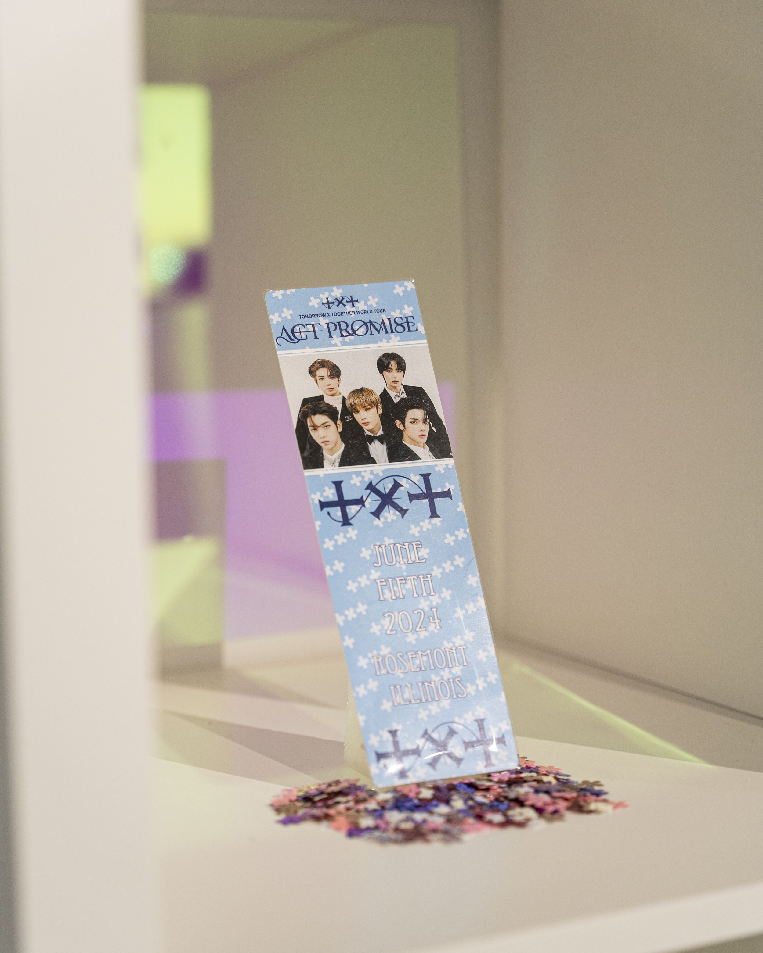 A bookmark-like concert object for Tomorrow x Together World Tour: Act Promise in blue and white, featuring a photo of five musicians.