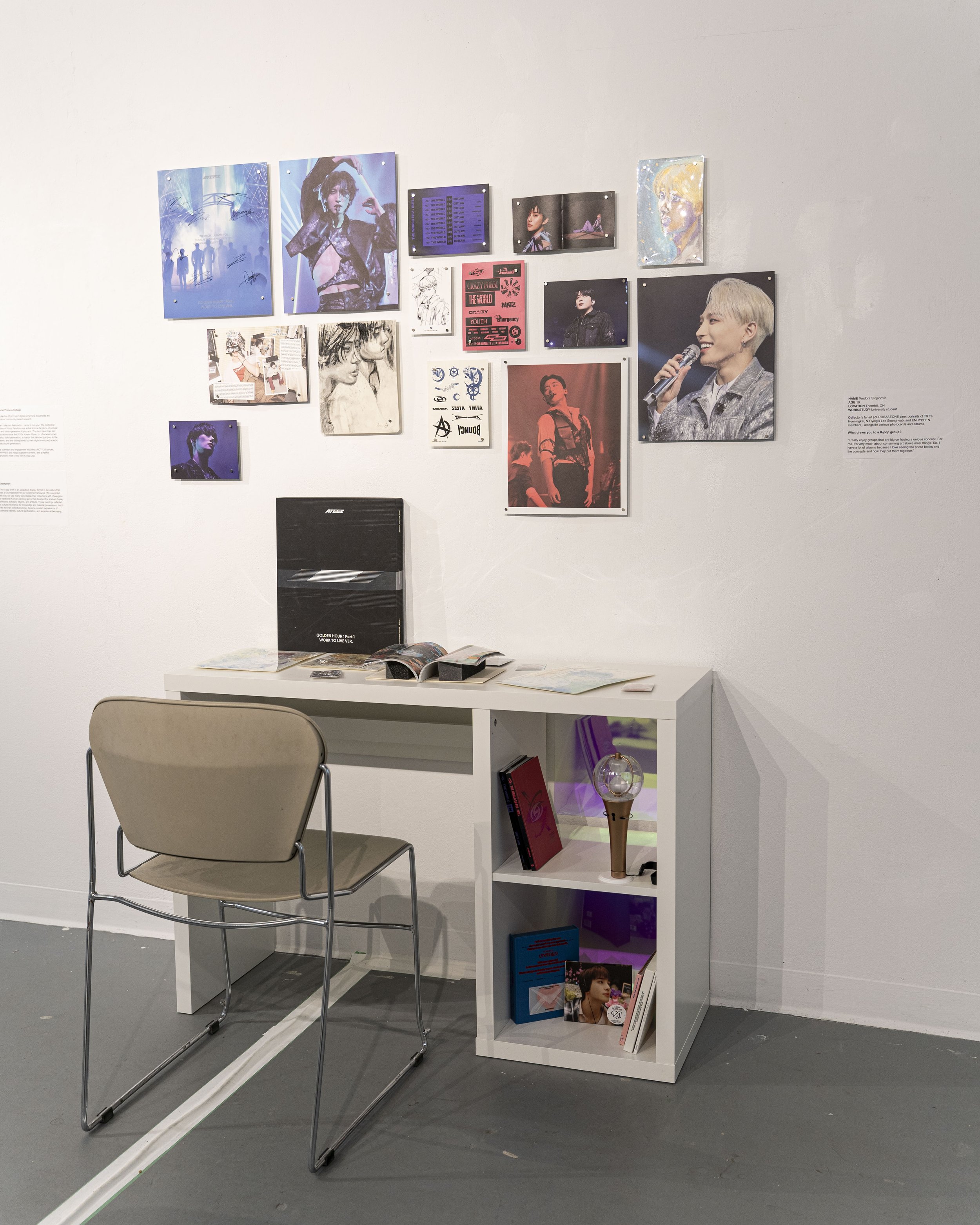 Photo of a desk with K-pop images and fanart on top of it and on the wall above it.