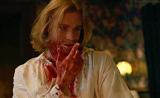 Animated gif of Lestat from IWTV, covered in blood, giving a come hither gesture with his finger