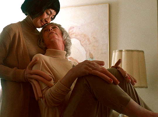 Animated gif from Everything Everywhere All at Once featuring Evelyn and Deirdre in the hot-dog hand universe, nuzzle each other