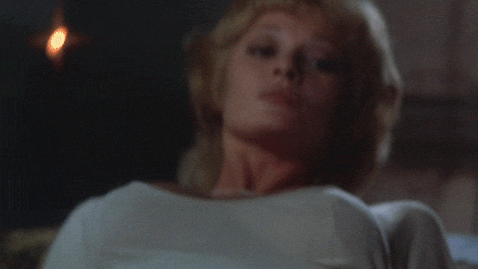 Animated gif of Dracula repelled by a cross on a woman's neck from Dracula A.D. 1972
