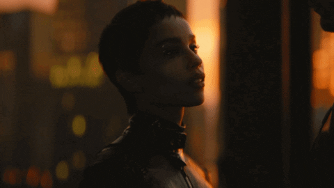 Gif of Zoë Kravitz as Catwoman touching the mask of Robert Pattinson as Batman