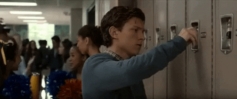 Animated gif of Peter Parker opening a locker with some cheerleaders in the background