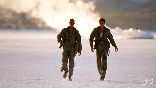 Animated gif of Will Smith and Jeff Goldblum walking through the desert in flight suits at the end of Independence Day