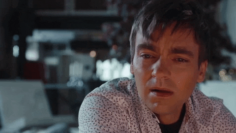 Carey from The Other Two imitating the final shot of Call Me By Your Name (crying in front of a fire)