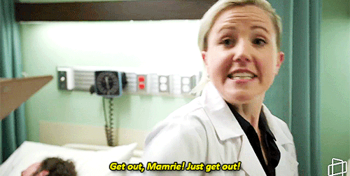  Hannah Hart playing a doctor in a FANtasies clip. She shouts “Get out, Mamrie! Just get out!” 