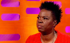  An animated gif of Leslie Jones breaking into a stunning smile and then laughter. 