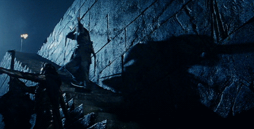  An animated gif of Legolas, from the  Lord of the Rings  movies, using a shield to surf down a staircase while shooting enemies with a bow. 