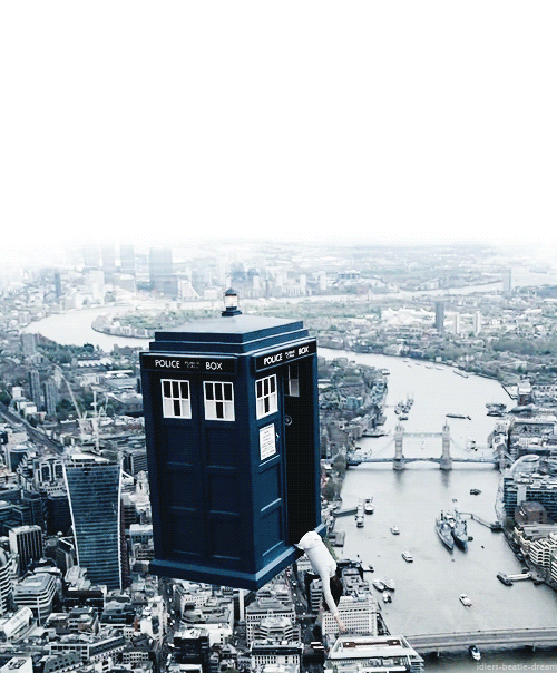  An animated gif of a woman hanging half-in, half-out of the TARDIS from Doctor Who, as it flies over London. 