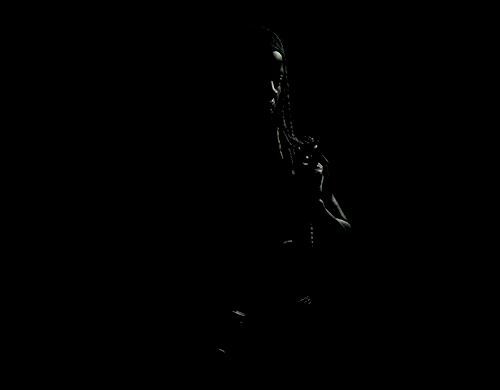  An animated gif of Michonne from  The Walking Dead , lovingly holding a machete, passing in and out of darkness. 