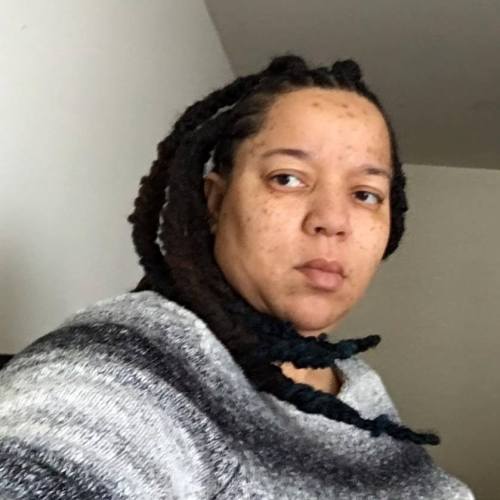  An image of Tanya DePass, wearing a white-black-grey gradient sweater. 