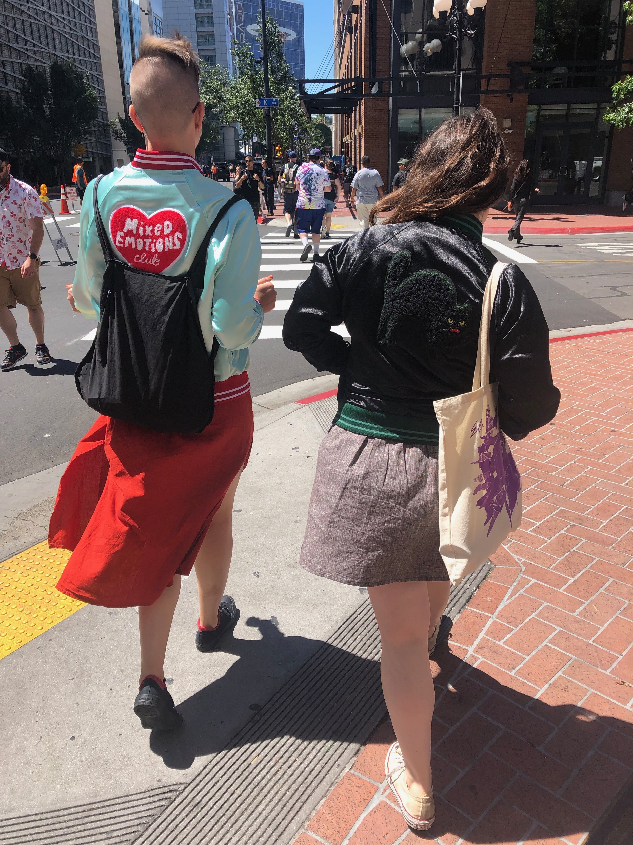 Photograph of Flourish and Zan walking down the street in San Diego, taken from behind.