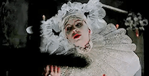 Animated gif of Lucy in her iconic white costume reeling at a cross in Bram Stoker's Dracula