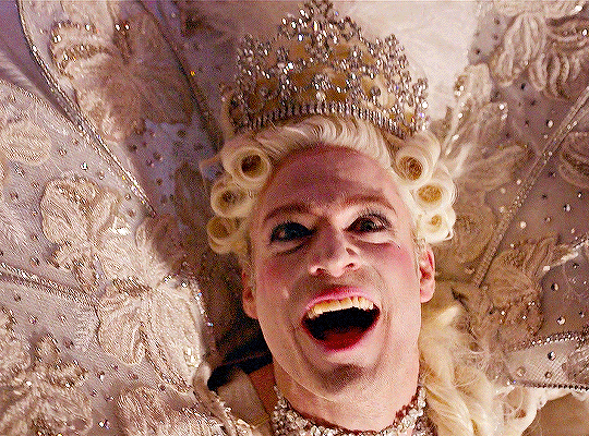 Animated gif of Lestat in his dramatic white feathered queen outfit from the Mardi Gras float.