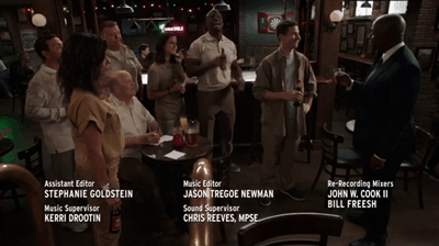  The Brooklyn Nine-Nine crew raises their glasses, shouting “NINE-NINE!” 