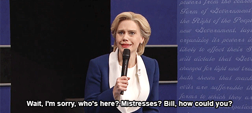 A gif of Kate McKinnon as Hillary Clinton saying “Wait, I’m sorry, who’s here? Mistresses? Bill, how could you?”
