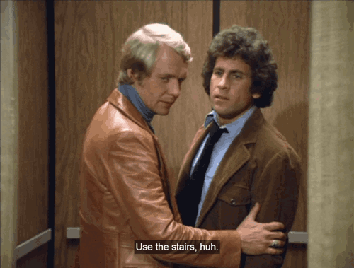  Starsky and Hutch in an elevator together, standing close, with the caption "use the stairs, huh."