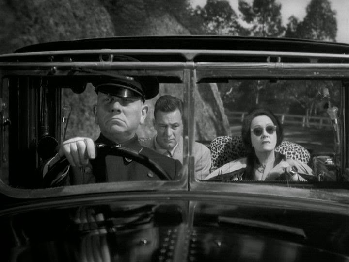Still image from Sunset Boulevard of Joe and Norma being driven in her car by Max