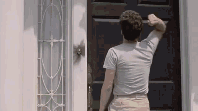 Animated gif from The Money Pit in which Tom Hanks bangs on the door until it falls off its hinges.