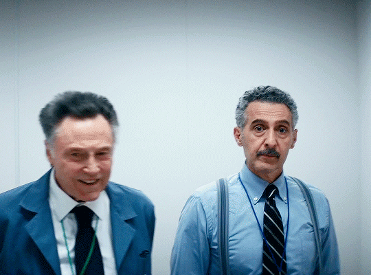 Burt G. and Irving B. from Severance, walking side by side in the office, laughing