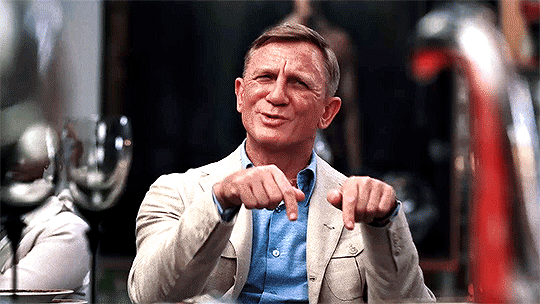 Animated gif of Daniel Craig as Benoit Blanc in Glass Onion, dressed in a blue button down shirt and tan blazer.