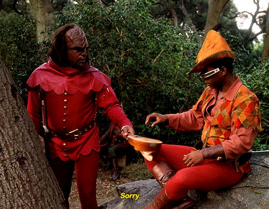 Animated gif of Worf and Geordie in Robin Hood costumes. Worf hands Geordie a broken lute with the caption "Sorry"