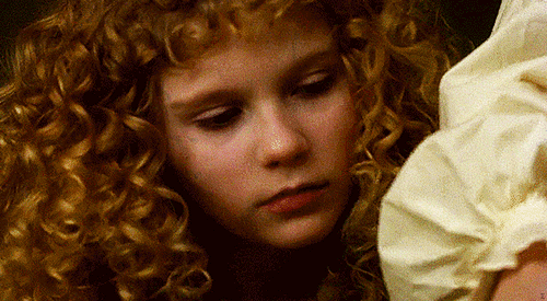 Animated gif of Kirsten Dunst as Claudia leaning in to bite someone's neck