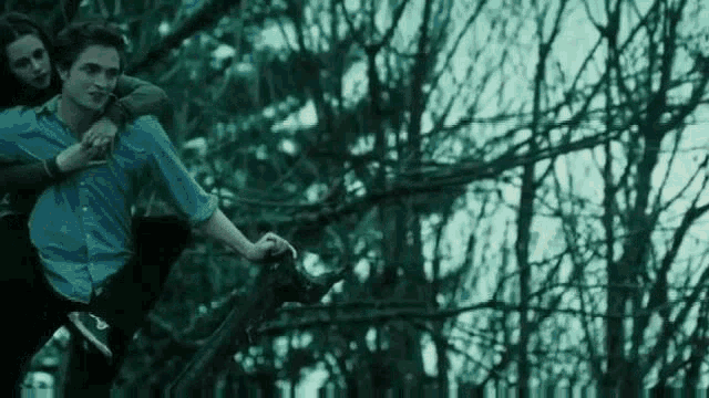 Animated gif from Twilight featuring Bella riding on the back of Edward as he jumps and sails in the air from one tall pine tree to another