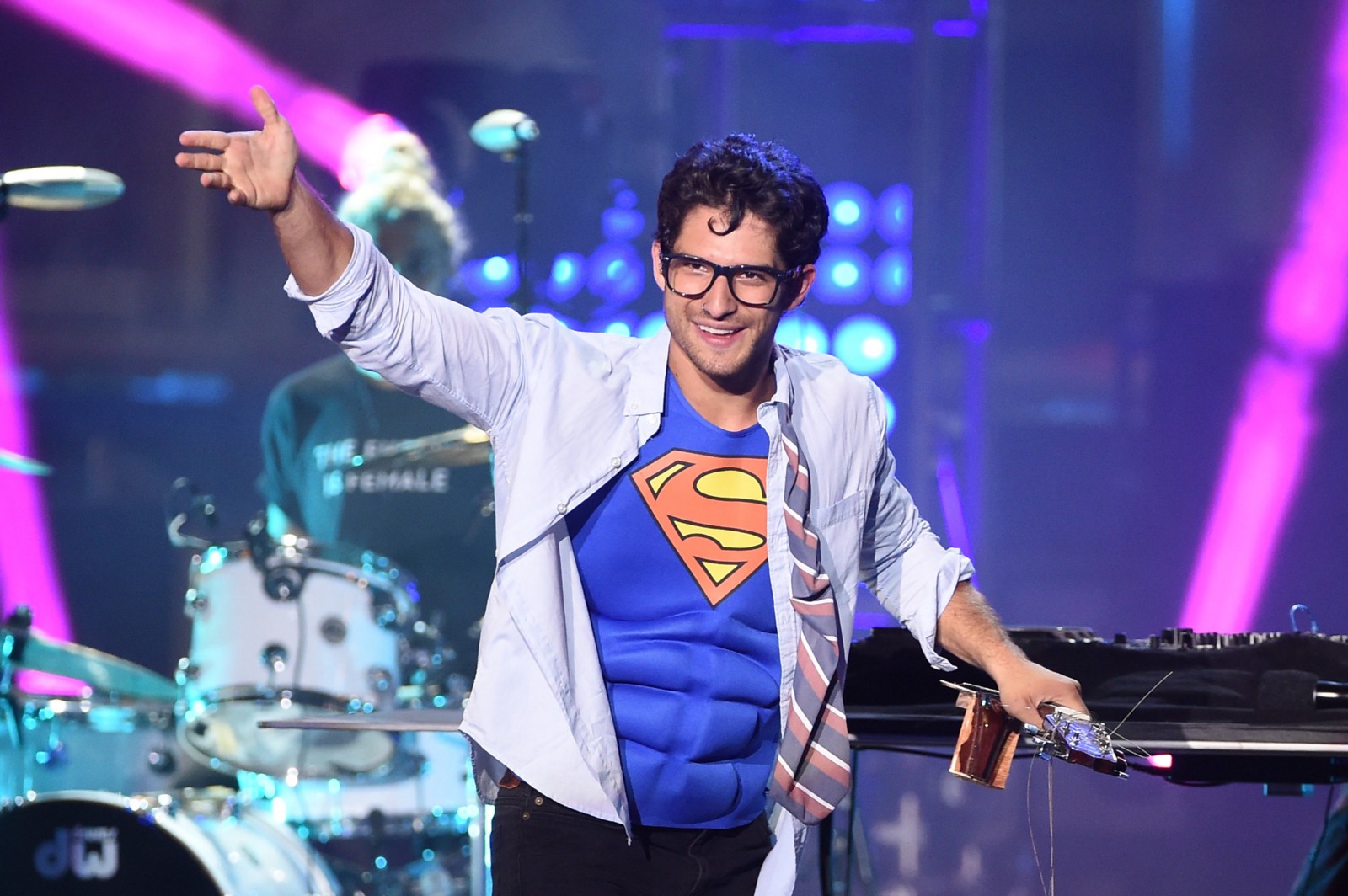 Photograph of Tyler Posey in a superman shirt with fake muscles for abs.