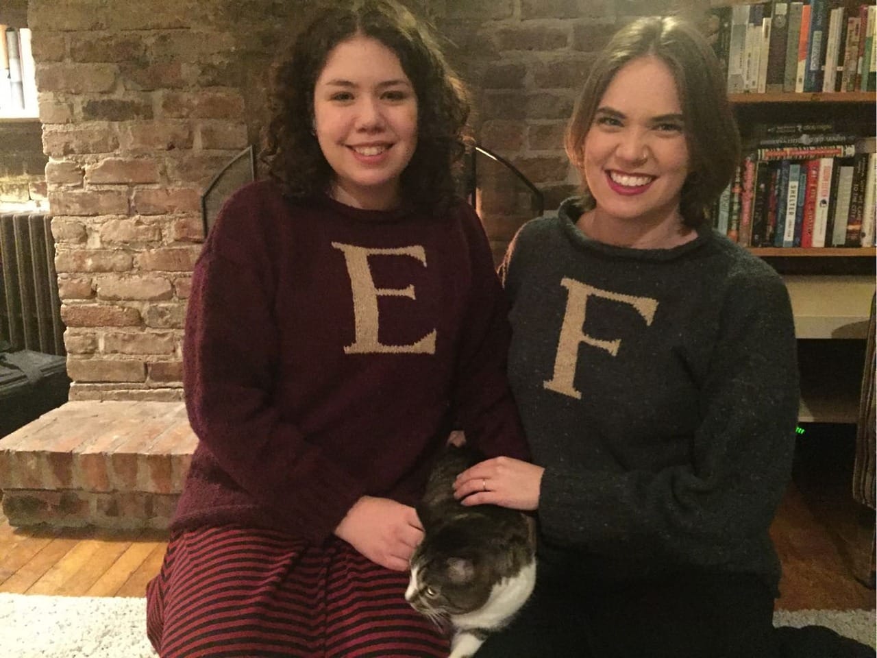 Flourish and Elizabeth wearing matching Harry Potter sweaters, with Orlando the cat between them.