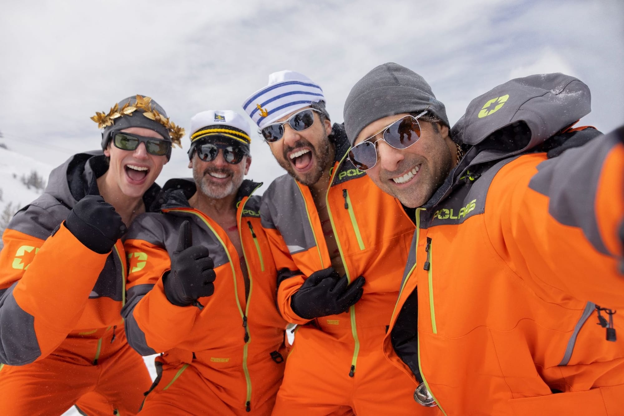Image of the four tech titans in the movie all dressed in matching orange snowsuits, sunglasses, and a variety of goofy hats, taken like a selfie.