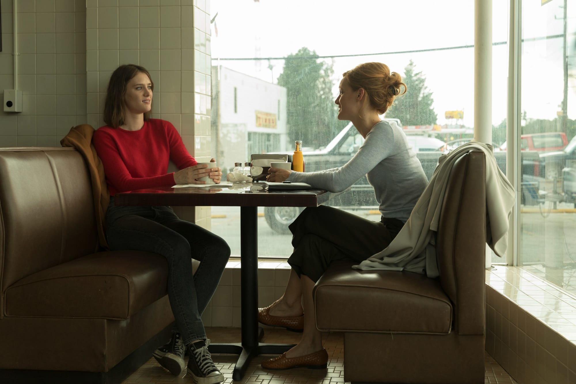 Production still of Cameron and Donna sitting in a booth at a diner.
