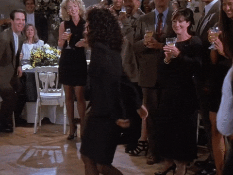 Animated gif of the famous Elaine dancing scene in Seinfeld featuring Elaine thrusting her thumbs upwards and kicking her legs as she jams.