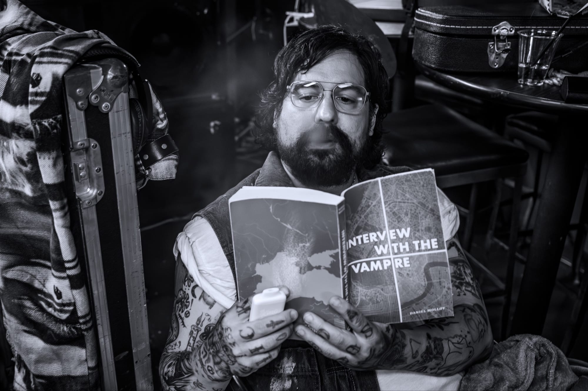 Black and white image of Salamander reading IWTV while he vapes.