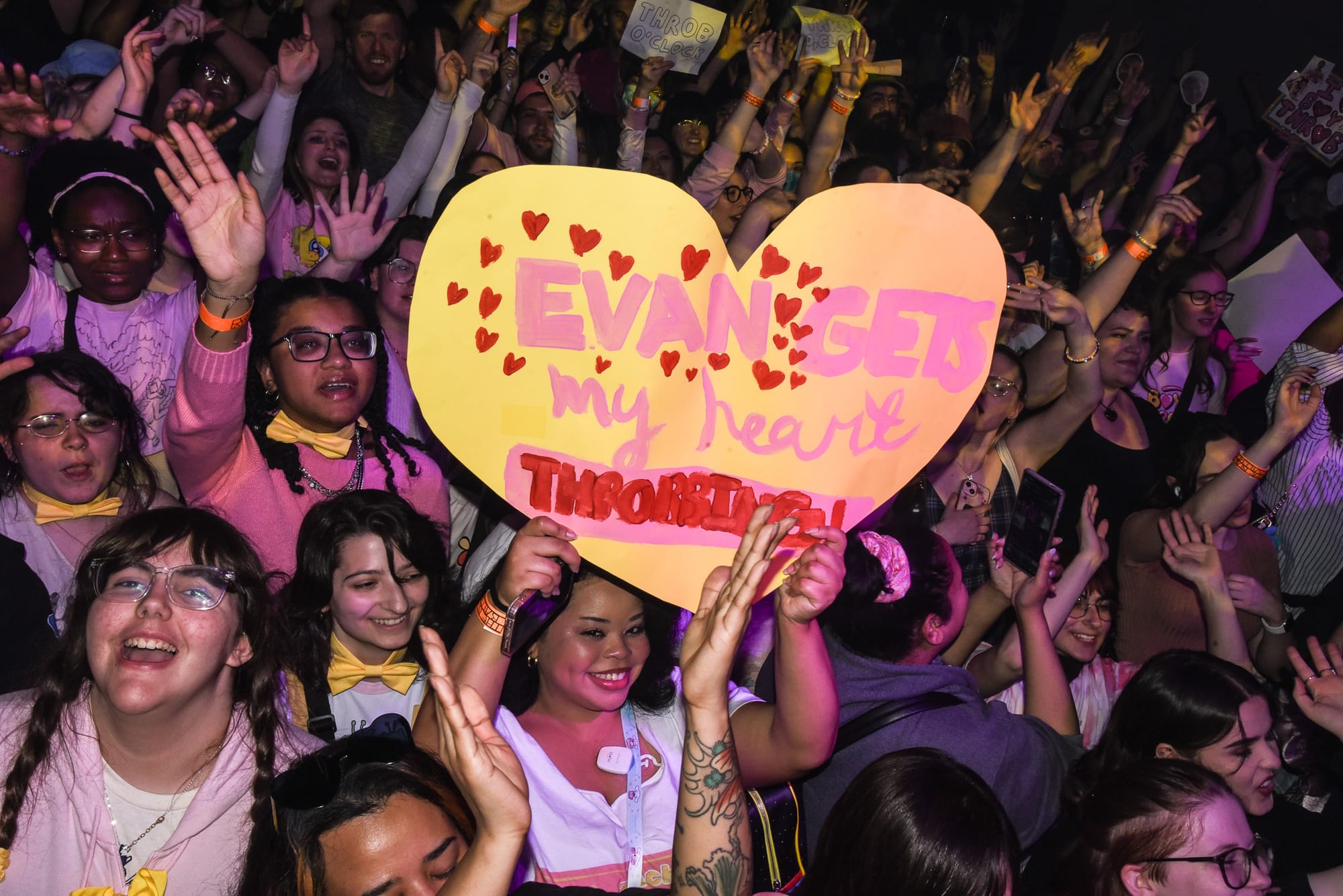 Image of Boy Throb fans in the crowd, with one fan in the center holding up a heart sign with the text Evan Gets my heart.