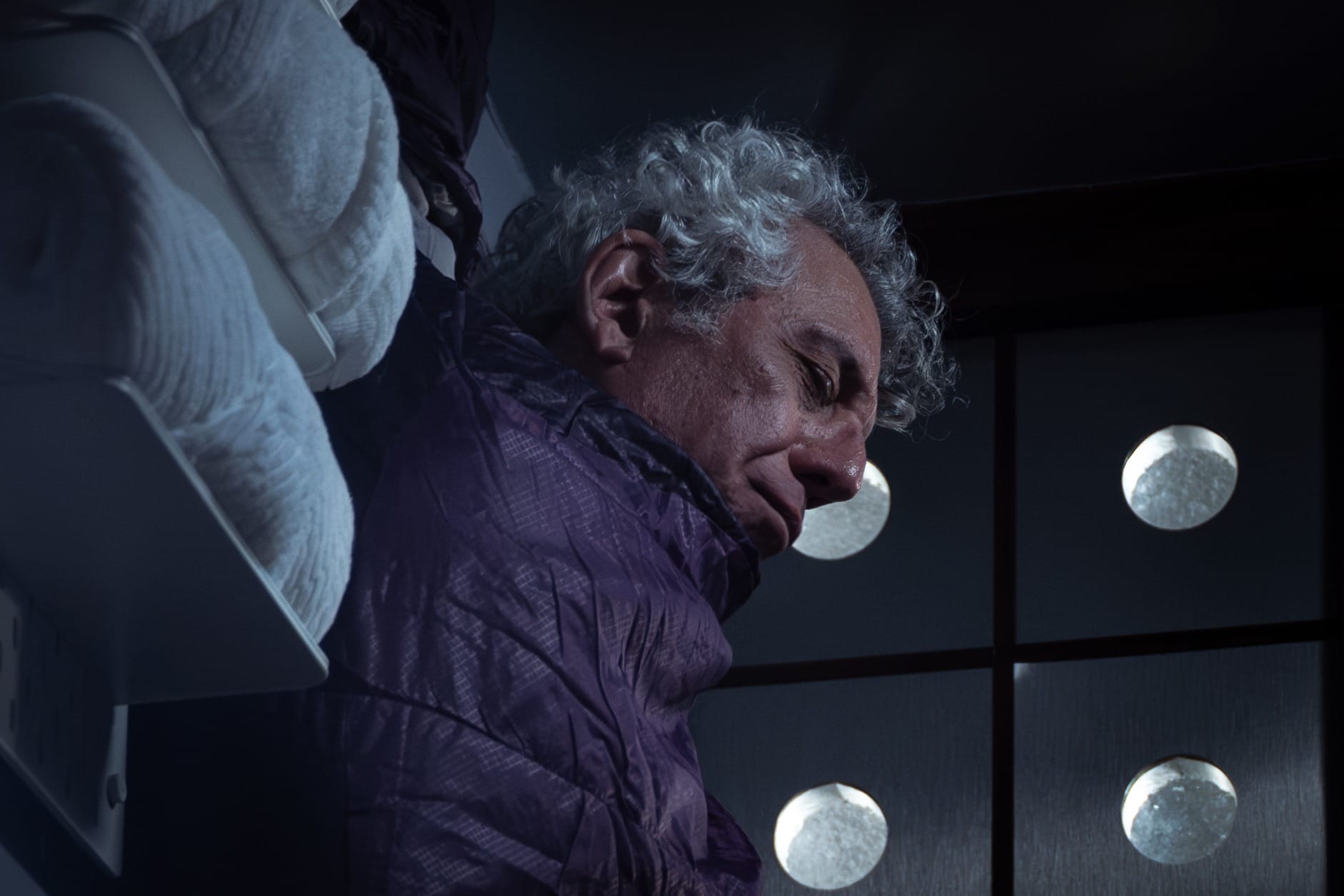 Production still featuring Daniel sleeping in his purple sleeping bag, positioned vertically.