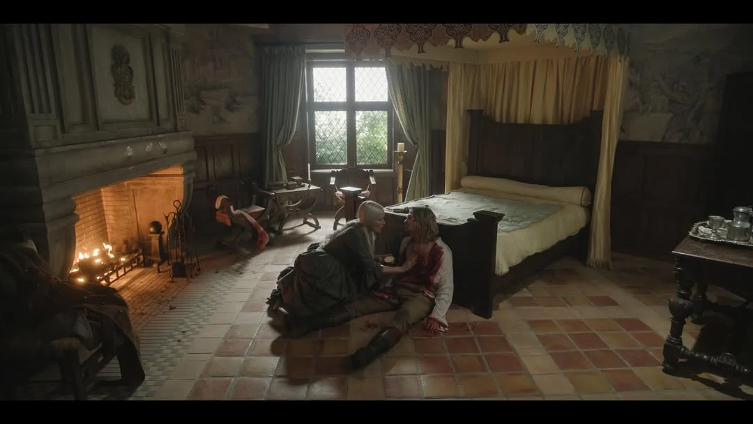 Image from TVL featuring Gabriella and Lestat in Lestat's bedroom, as he sits against the foot of his bed.