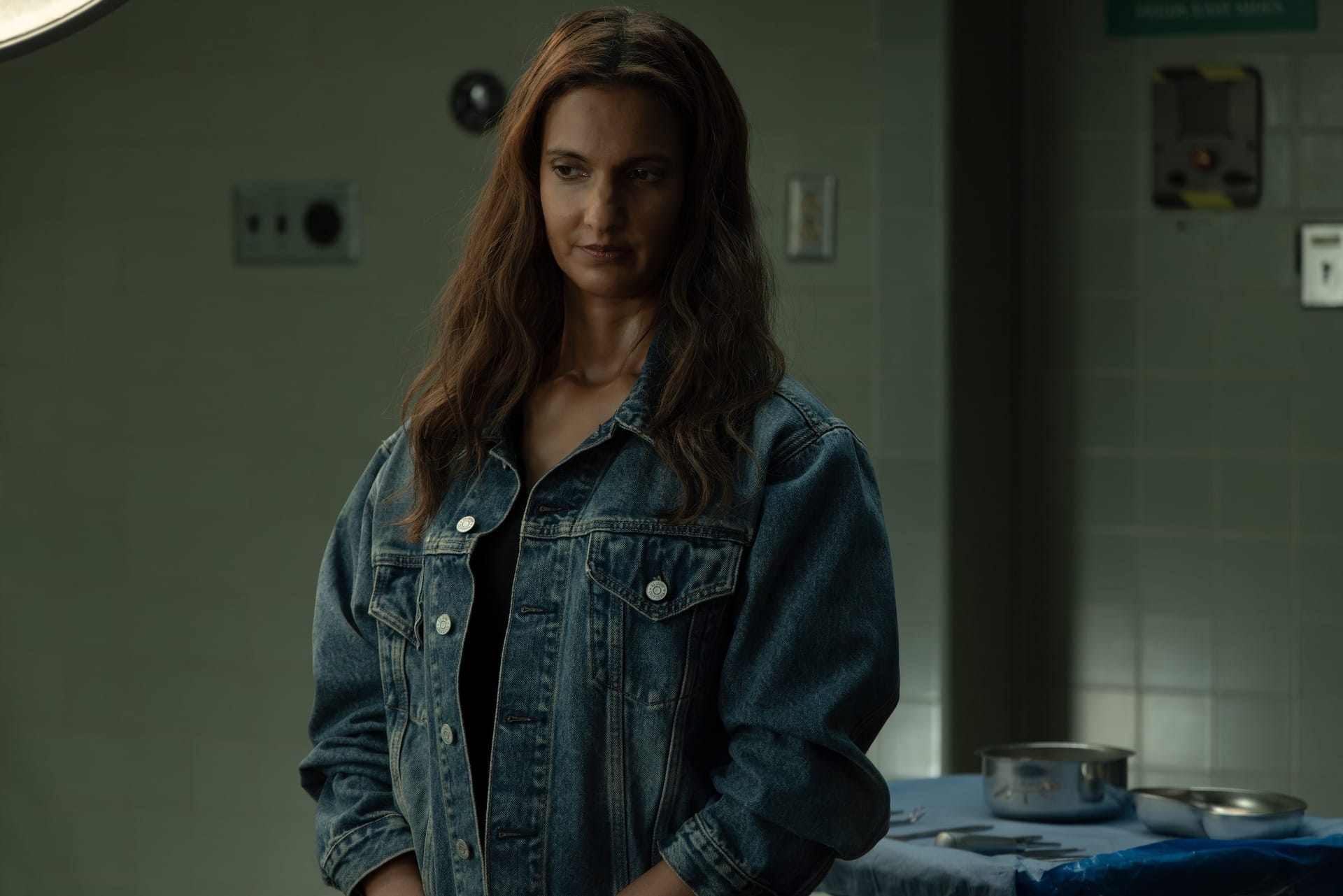 Production still of Zoe in a denim jacket in a hospital setting