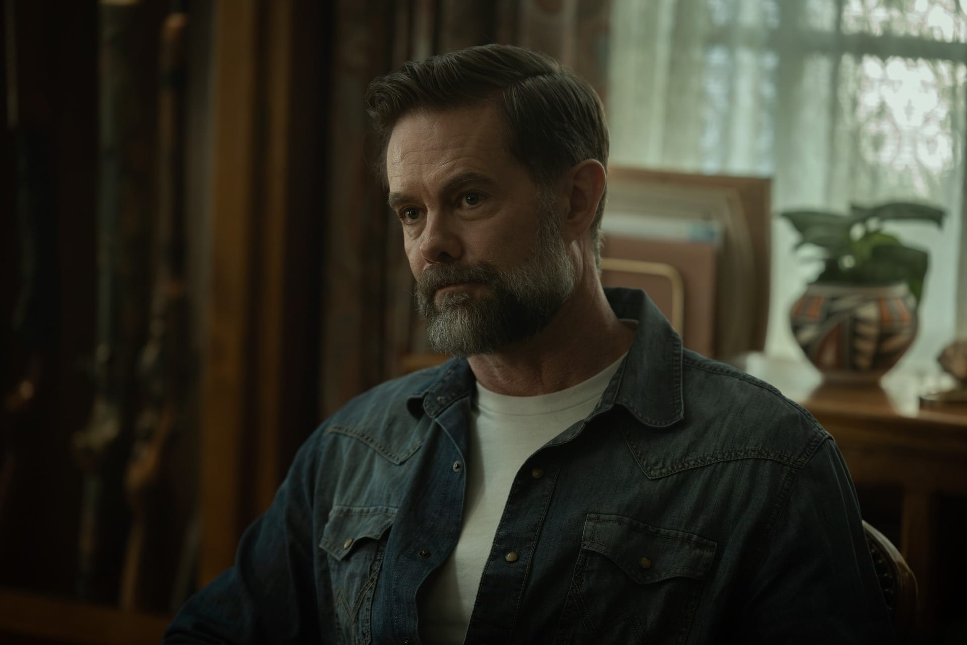 Production still of Macon in a denim shirt.