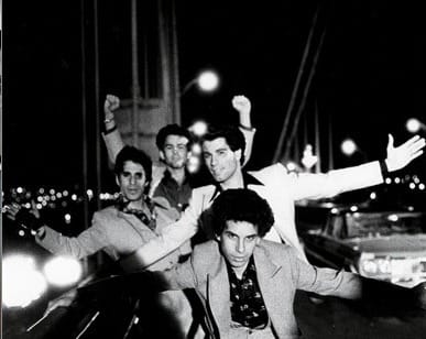 Black and white photo of the "boys" of Saturday Night Fever posing on the Verrazano Bridge