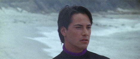Animated gif of Keanu walking along the surf in Point Break