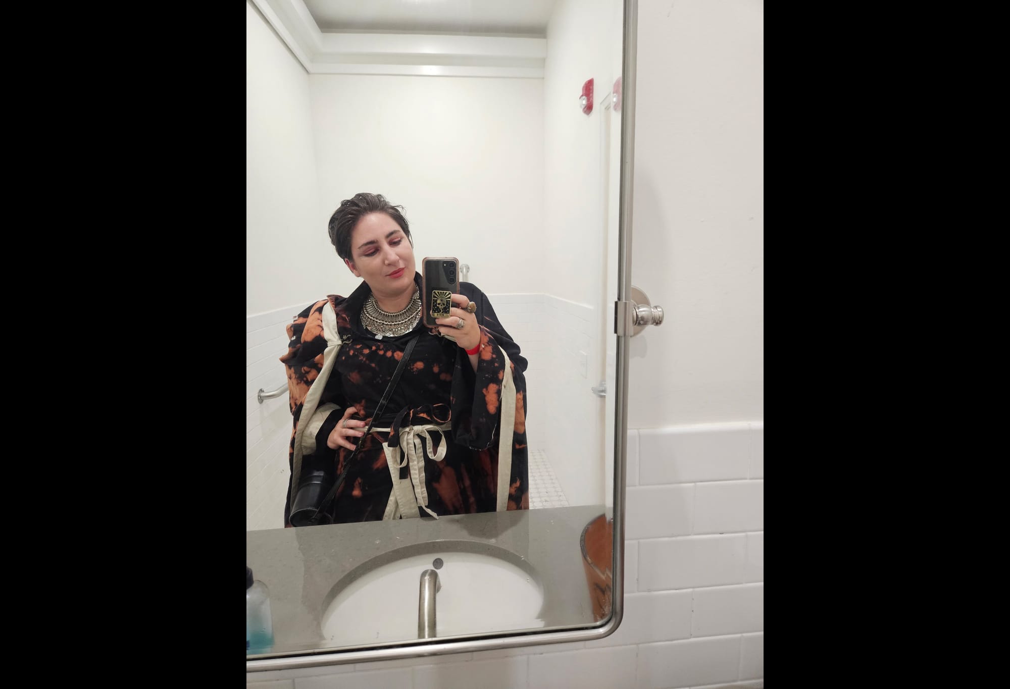 Selfie of Lin in the bathroom mirror. They are wearing their "not a wizard" costume.