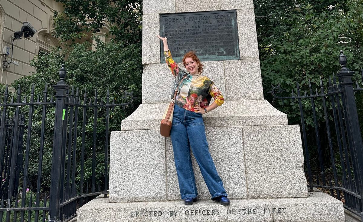Photograph of Allegra in front of a statue of Robert Falcon Scott.