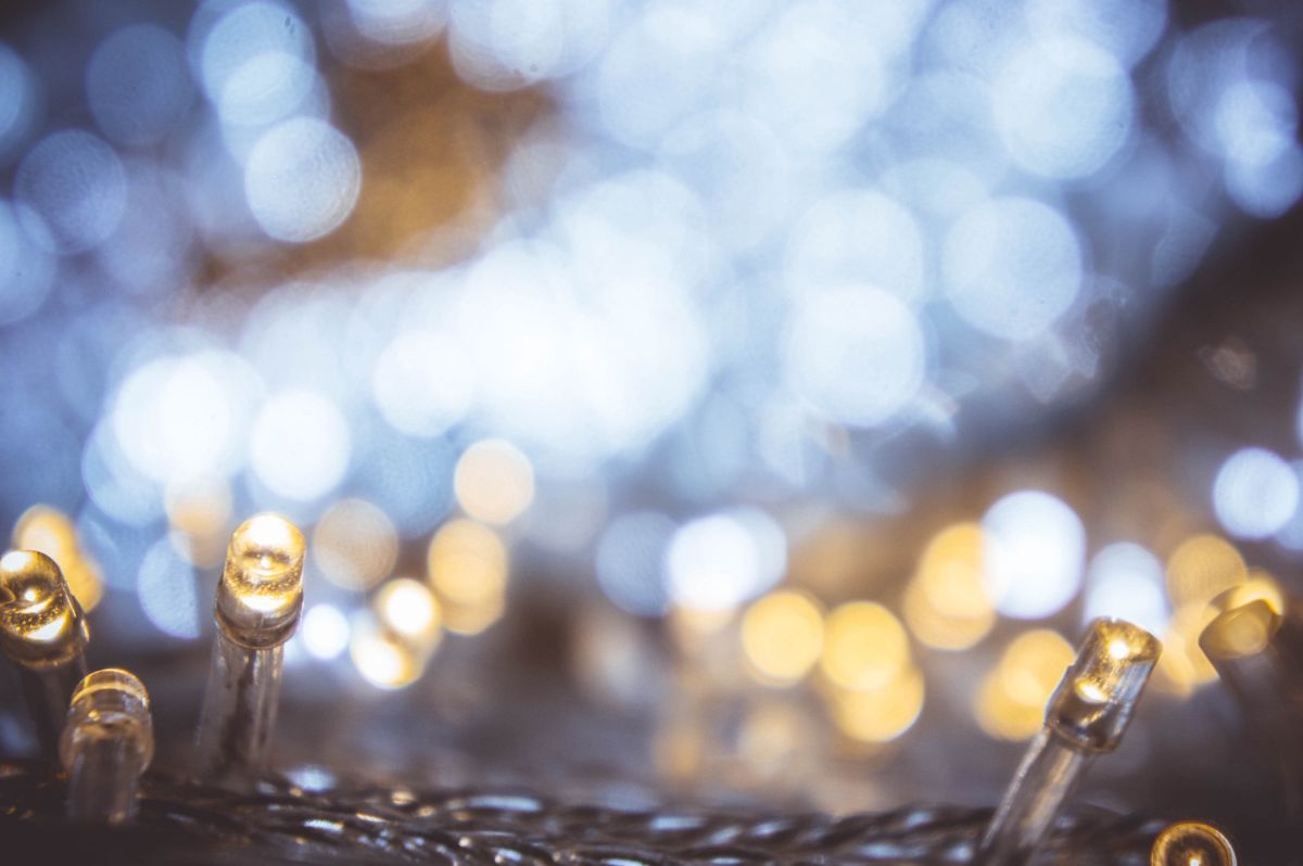 A photograph of white holiday lights, a bokeh effect transforming them into abstract twinkles.