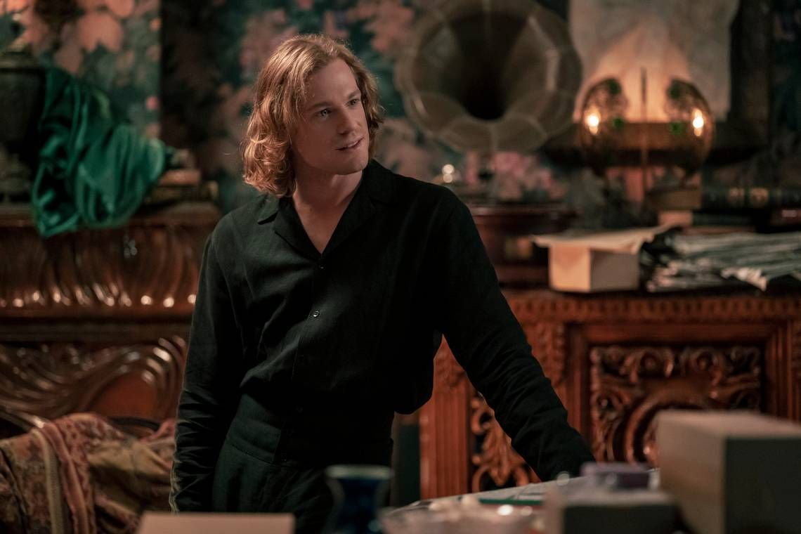 Lestat from AMC's Interview with the Vampire dressed in all black and leaning against a table.