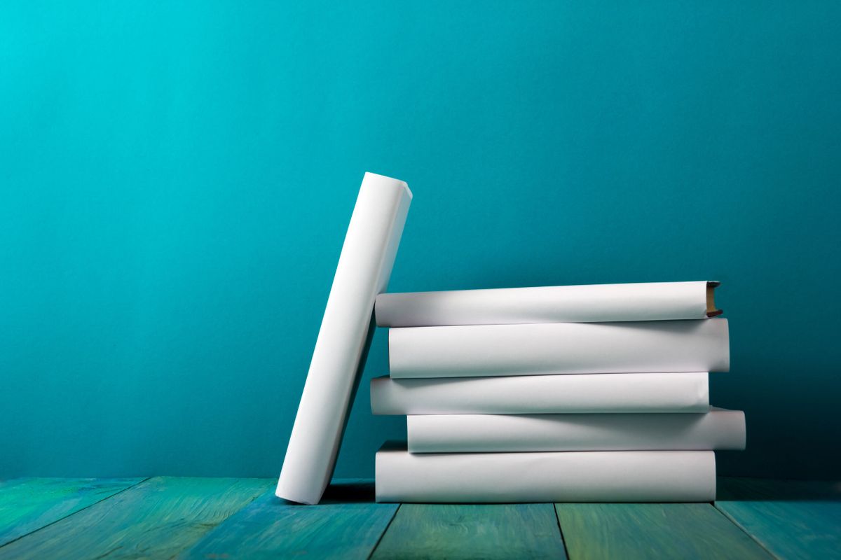  A stack of blank white books against a deep turquoise background. 